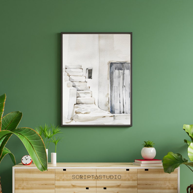 May include: A watercolor painting of a white building with a door and steps. The painting is framed in black and is hanging on a green wall.
