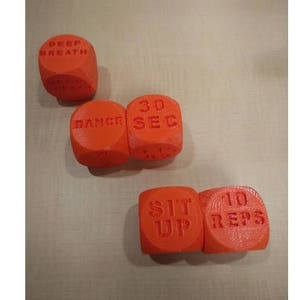 May include: Set of six orange dice with different workout instructions printed on each side. The dice read "Deep Breath", "Dance", "30 Sec", "Sit Up", "10 Reps".