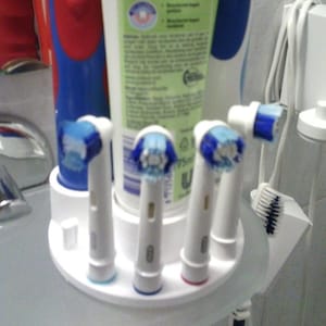 May include: An assortment of electric toothbrushes and replacement brush heads. The toothbrushes are red and blue, and the brush heads are white with blue bristles. A tube of toothpaste is also visible.