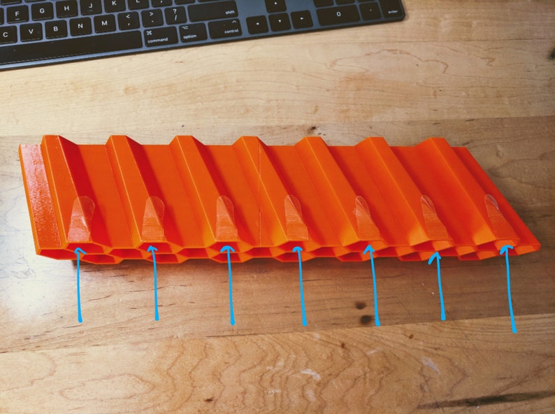 Op de afbeelding: Oranje plastic baan met een honingraatontwerp en acht verhoogde secties. De baan is ontworpen voor speelgoedauto's.