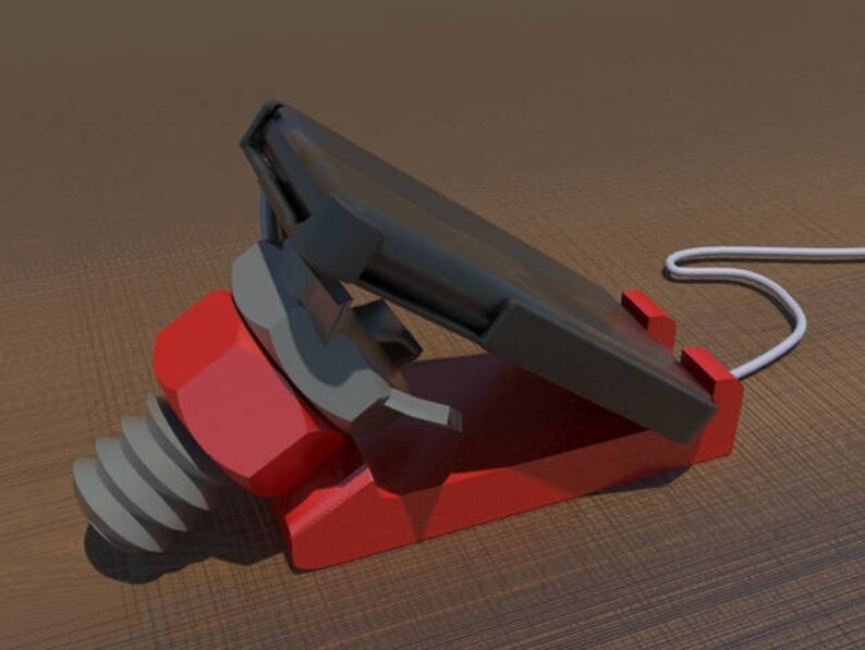 May include: A red and black phone stand with a white cord. The stand has a screw-like base and a slot for a phone.