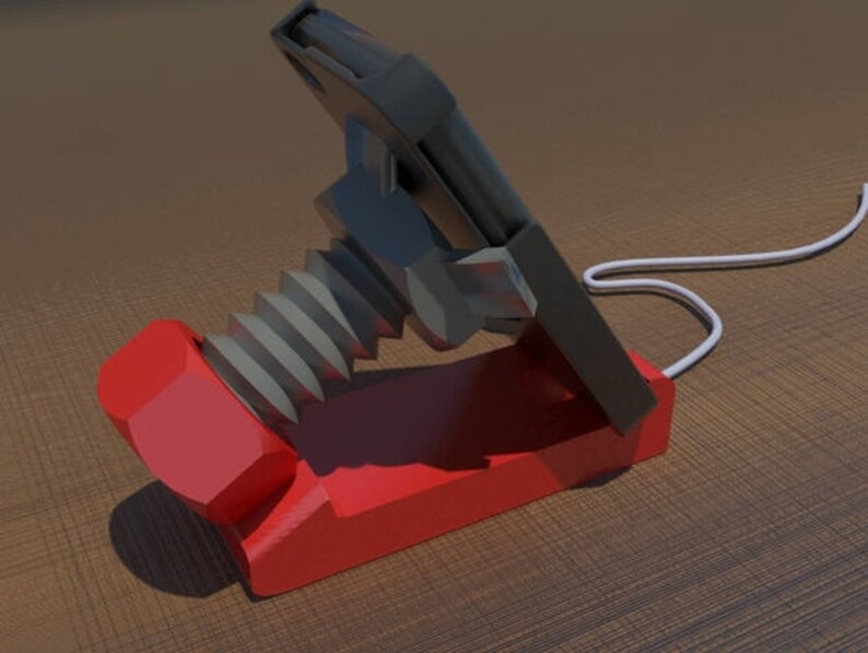 May include: A red and black phone stand with a screw-like design. The stand is made of plastic and has a white cord attached to it.