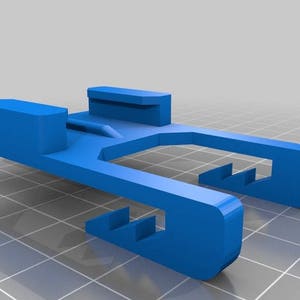 May include: A blue plastic 3D printed part with a slot in the middle and a series of teeth on the sides.