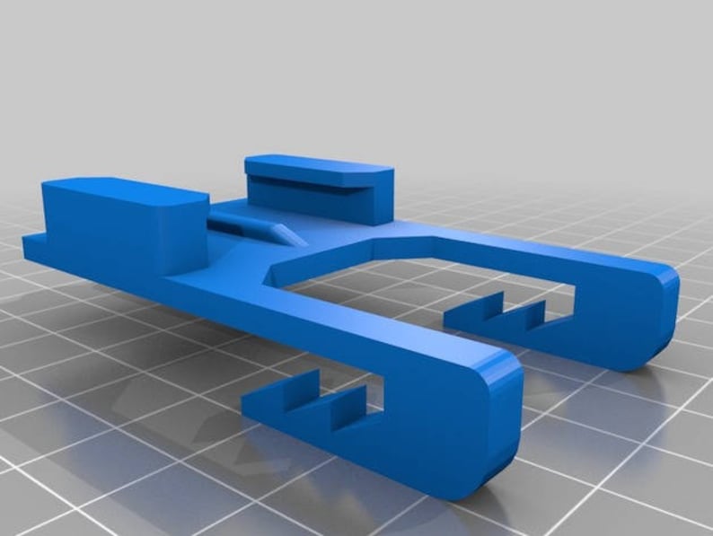 May include: A blue plastic 3D printed part with a slot in the middle and a series of teeth on the sides.