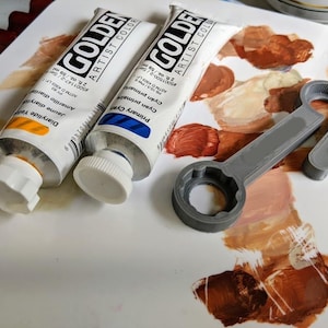 Schraubenschlüssel zum Öffnen der goldenen Acrylfarb Tube