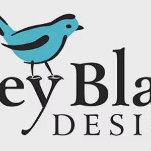 Op de afbeelding: Een logo met een gestileerde lichtblauwe vogel met zwarte omlijningen die op de letter y van de zwarte tekst Riley Blake DESIGNS zit. De vogel heeft een kleine zwarte snavel en zwarte vleugeldetails. Het geregistreerde handelsmerksymbool staat aan het einde.