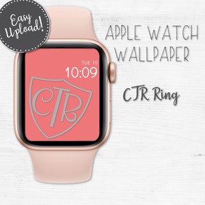 May include: A pink Apple Watch with a rose gold band and a red face. The face has a shield with the letters "CTR" inside. The time is 10:09. The text "APPLE WATCH WALLPAPER CTR Ring" is displayed above the watch.