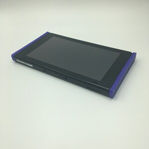 May include: A black Nintendo Switch console with purple edges. The console is in a closed position, with the screen facing up.