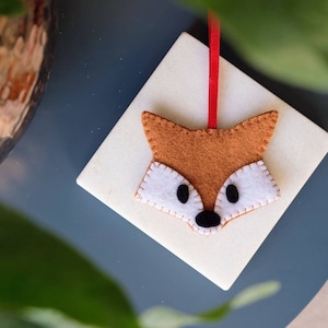 A beautiful hand sewn felt fox Christmas tree decoration with blanket stitch detailing and a red satin ribbon for hanging. Stocking filler.