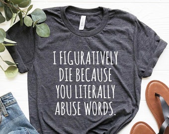 May include: A dark gray t-shirt with the text "I figuratively die because you literally abuse words." printed in white.