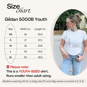 以下が含まれることがあります： Gildan 5000B Youth Tシャツのサイズチャート。チャートはXSからXLまでのサイズを示し、対応する幅と長さはインチで表示されています。ご注意ください：これはYOUTH-SIZEDシャツです。大人のサイズよりも小さくなっています。モデルはXSを着用しており、ベビーTシャツのフィット感です（通常はレディースS、4-6を着用しています）。