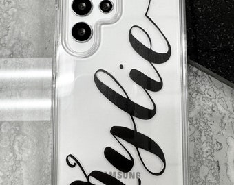 May include: A clear phone case with a black inscription that says "Julie" on a white background. The case has a camera cutout on the back.