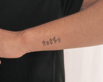 May include: A close-up of a person's wrist with a small line of five cactus tattoos.