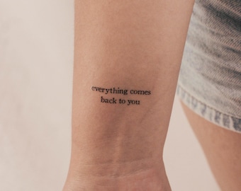 May include: A close-up of a person's wrist with a simple black tattoo that reads "everything comes back to you".
