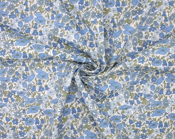 May include: A fabric with a floral pattern in shades of blue and green on a white background. The design features various flower shapes, including bell-shaped and daisy-like blooms, creating a dense, all-over pattern. The fabric is likely cotton or a similar material.