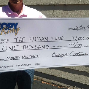 Peut inclure: Un chèque blanc de grande taille pour 1 000,00 $ libellé à l'ordre de "The Human Fund" de la part de "Copy King" daté du 12/23/17. La ligne de mémo indique "Money for People".