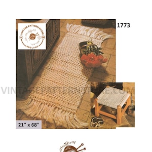 May include: A beige macrame rug with fringe on the ends. The rug is 21 inches by 68 inches. The rug is on a wooden floor with a wooden stool in the background.