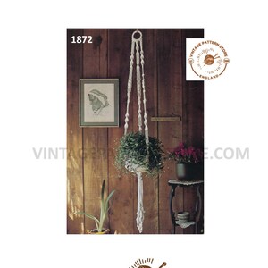 Peut inclure: Un modèle vintage de suspension de plante en macramé, avec une photo d'une suspension de plante en macramé terminée dans une pièce en bois. Le modèle est de Vintage Pattern Store, Angleterre. Le numéro du modèle est 1872.