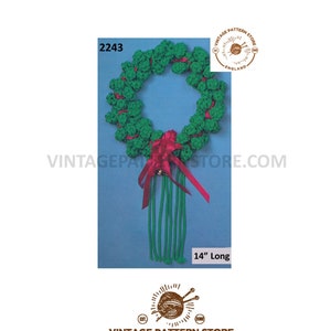 May include: A green and red crocheted Christmas wreath with a red bow and a bell. The wreath is 14 inches long.