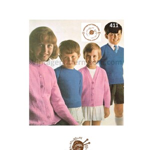 Könnte beinhalten: Bild vom Vintage Pattern Store mit vier Kindern in Strickwaren. Zwei tragen rosa Strickjacken, einer einen blauen Pullover und ein weiterer einen blauen V-Ausschnitt-Pullover. Das Bild enthält den Text "Vintage Pattern Store England" und die Nummer "411".