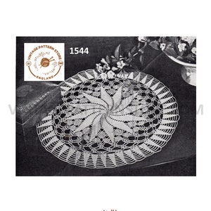 May include: A white crochet doily with a spiral design. The doily is on a dark surface and has a vintage pattern store logo in the corner. The logo says "Vintage Pattern Store" and "England".