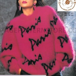 May include: A pink fuzzy sweater with black "Paris" lettering. The sweater is a size 34-38 inches chest and is made of mohair/DK yarn.
