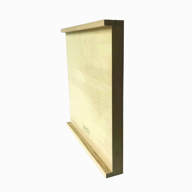 May include: A light wood wall shelf with a lip on the bottom edge. The shelf is made of plywood and has a natural wood finish. The text "LYMOU" is printed on the shelf.
