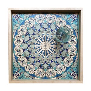 May include: A wooden tray with a blue and white geometric pattern. The tray has a light wood frame and a glass on top.