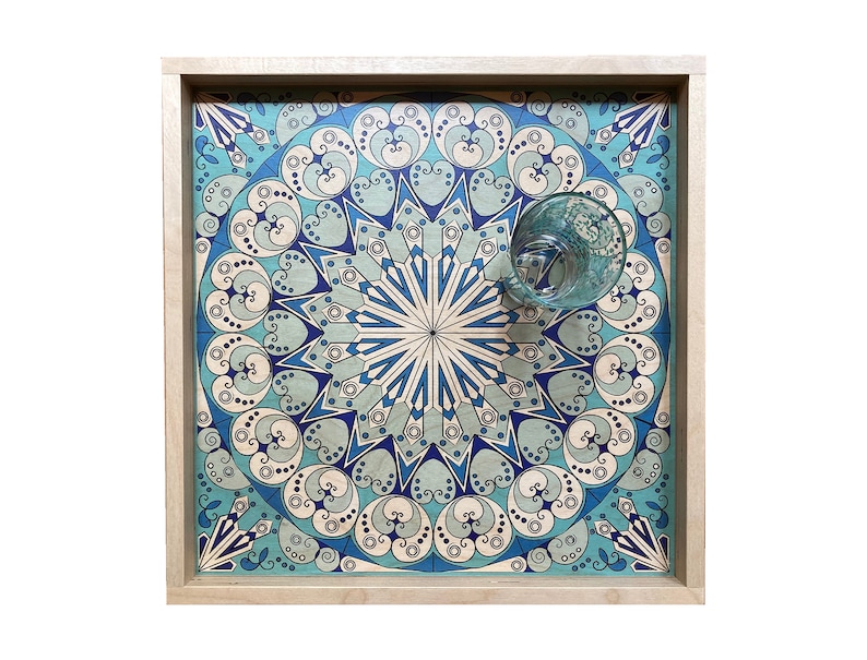 May include: A wooden tray with a blue and white geometric pattern. The tray has a light wood frame and a glass on top.