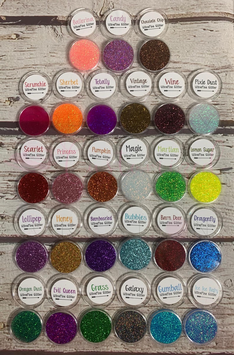 May include: A collection of 30 small jars filled with various colors of ultra-fine glitter. Each jar has a label with the name of the glitter color and the words "Ultrafine Glitter".
