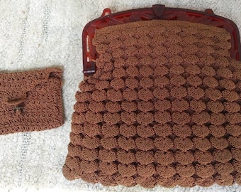 A cute brown hand crocheted purse with a lucite/celluloid type closure and has a matching coin purse. #156