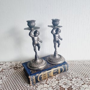 Pair of ornate vintage silverplate candlestick holders with cherubs