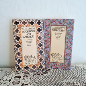 May include: Two vintage Good Housekeeping books on patchwork and embroidery. The patchwork book has a star pattern border, while the embroidery book features a floral design. Both books have text and illustrations.