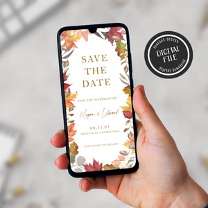 May include: A digital save the date card with a fall theme. The card features a wreath of autumn leaves in shades of red, orange, and yellow, with gold accents. The text "Save the Date" is written in gold lettering, and the couple's names and wedding date are listed below. The card is displayed on a smartphone.