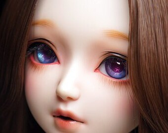 May include: A doll with long brown hair, wearing a white lace dress and a gold necklace with small flower charms. The doll has blue eyes with purple accents.