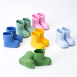 Op de afbeelding: Een set van tien kleurrijke regenlaarzen voor kinderen. De laarzen zijn gemaakt van een zacht, flexibel materiaal en zijn verkrijgbaar in verschillende kleuren, waaronder blauw, groen, geel en roze.