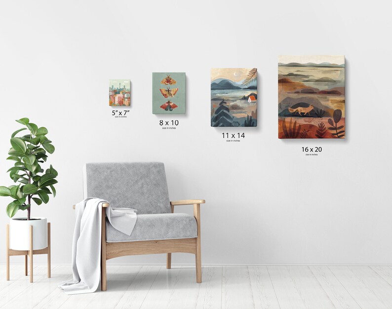 Puede incluir: Cuatro impresiones art&iacute;sticas en lienzo de varios tama&ntilde;os se exhiben en una pared blanca. Las impresiones presentan ilustraciones de un paisaje urbano, polillas, un paisaje con una casa y un paisaje con un zorro. Los tama&ntilde;os son 12,7 cm x 17,8 cm, 20,3 cm x 25,4 cm, 27,9 cm x 35,6 cm y 40,6 cm x 50,8 cm.