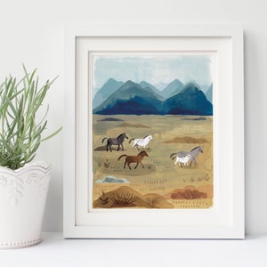 Puede incluir: Impresi&oacute;n art&iacute;stica enmarcada que presenta una pintura de acuarela de caballos en un paisaje. La obra representa varios caballos en tonos grises, marrones y blancos, sobre un fondo de monta&ntilde;as azules y un campo beige.