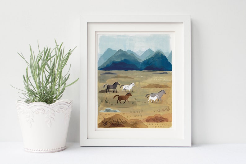 Puede incluir: Impresi&oacute;n art&iacute;stica enmarcada que presenta una pintura de acuarela de caballos en un paisaje. La obra representa varios caballos en tonos grises, marrones y blancos, sobre un fondo de monta&ntilde;as azules y un campo beige.