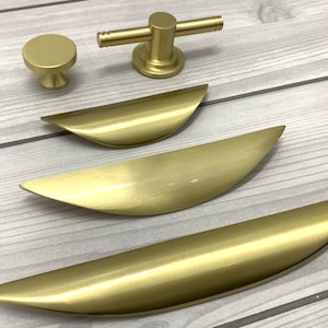 May include: Four gold-toned cabinet pulls, including a round knob and three different sizes of curved pulls.