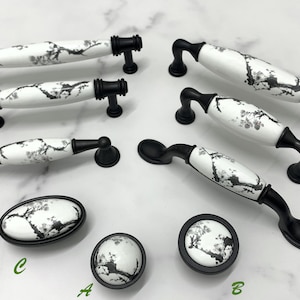 Peut inclure: Assortiment de boutons et de poignées de cabinet en céramique noire et blanche avec un motif floral. Les boutons et les poignées sont de différentes tailles et formes.