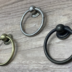 May include: Three ring pulls in different finishes: gold, silver, and black. The ring pulls are decorative and can be used for cabinets, drawers, or doors.