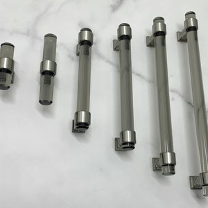 Könnte beinhalten: Satz mit sechs klaren Glas-Schrankgriffen mit gebürstetem Nickel-Finish. Die Griffe sind in verschiedenen Längen erhältlich.
