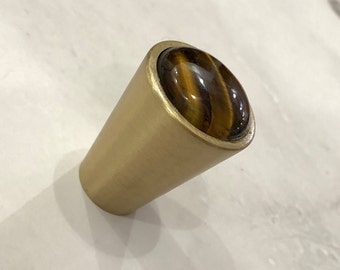 Könnte beinhalten: Ein goldfarbener Schrankknopf mit einem runden, braunen Tigerauge-Stein-Einsatz.