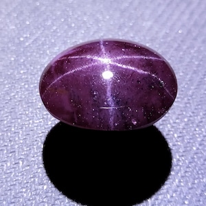 Cabujón de granate estrella de 6 rayos y 61 quilates: gema ovalada de color púrpura rojizo intenso.