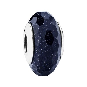 May include: A dark blue faceted glass bead with a silver metal core and a silver metal loop.