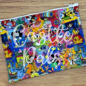 Peut inclure: Une pochette zippée colorée avec un design de dessin animé vibrant avec divers personnages et éléments. Le design comprend Mickey Mouse, Donald Duck et d'autres personnages, avec le texte "Create Magic" en cursive. La pochette a une fermeture éclair blanche.