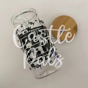 May include: Clear glass tumbler with a black and white graphic design that says "Pew Pew" and features starships. Includes a round wooden lid. A fun, themed drinking glass.