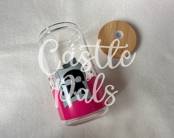 May include: A clear glass bottle with a pink and white design featuring a cartoon character. The bottle has a bamboo lid with a small hole in the center. The text "Castle Pals" is written on the bottle.