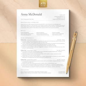 May include: A professional resume template for Anna McDonald featuring sections for professional overview, skills, work experience, and education, printed on white paper with black text, accompanied by a gold-colored metallic pen.